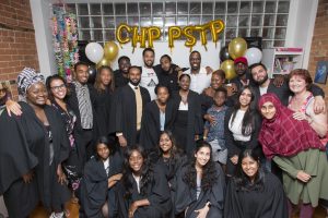 A group photo of a few dozen people standing in the Stella's Place Café with a gold balloon sign behind them that reads "CHP PSTP"