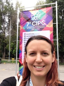 A selfie of Steph in front of the 7a CIPC conference banner