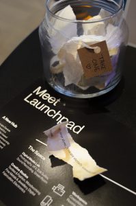 A closeup photo of crumpled paper on top of a flat black poster that reads "Meet Launchpad" in white text.