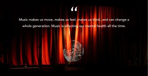A photo of a red curtain on a stage with a light shining in the middle through the darkness with a quote overlaid on top in white "Music makes us move, makes us feel, makes us think, and can change a whole generation. Music is affecting our mental health all the time."