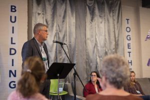Dr. Bjug Borgundvaag standing at the microphone in speech.