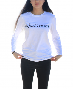 Photo of person with long hair from the neck down wearingwhite longsleeve t-shirt that says '[Smile]age" across the chest