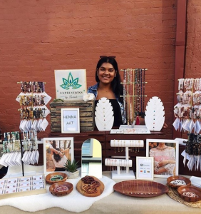 Image of person standing behind display of jewlery with brick background.