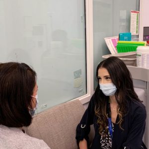 Yolanda, a Peer Support Worker speaks to a patient in an office room