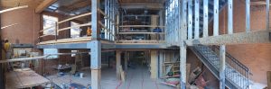 A panorama photo of the construction site at 54 Wosleley showing 2 floors with exposed beams and construction tools.
