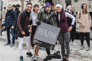 A group of people outside posing a picture and holding a banner that says "RUN"